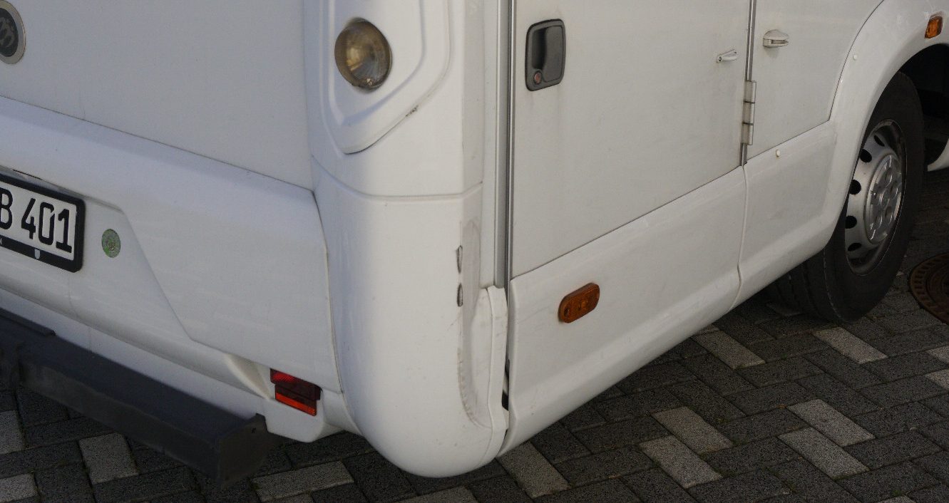 Unfallschaden an einem Wohnmobil mit Beschädigungen im hinteren rechten Eckbereich
